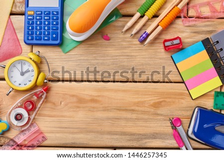 School stationery on wooden background with copy space. Educational background with different school or office supplies. Space for text.