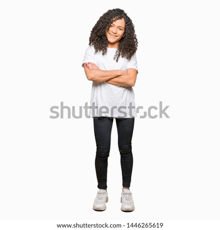 Young beautiful woman with curly hair wearing white t-shirt happy face smiling with crossed arms looking at the camera. Positive person.