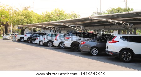 Closeup of rear, back side of white car with  other cars parking in parking lot under roof with natural background in bright sunny day. The mean of simply transportation in modern world. Royalty-Free Stock Photo #1446342656