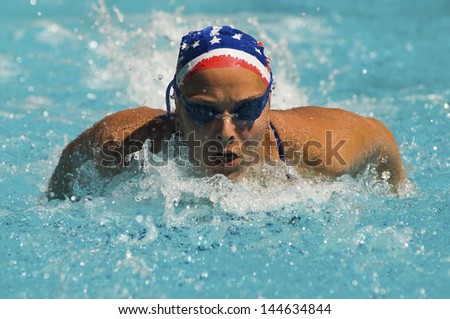 Closeup of a young woman swimming butterfly stroke