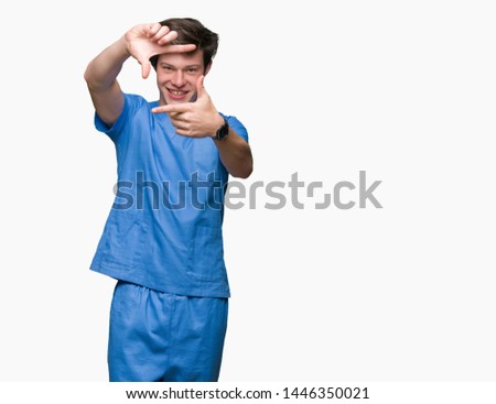 Young doctor wearing medical uniform over isolated background smiling making frame with hands and fingers with happy face. Creativity and photography concept.
