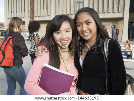 Two female students outside school (portrait) Royalty-Free Stock Photo #144635195