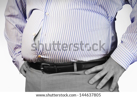 Closeup midsection of an overweight man standing with unbuttoned shirt and hands on hip