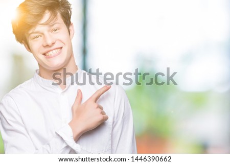 Young handsome business man over isolated background cheerful with a smile of face pointing with hand and finger up to the side with happy and natural expression on face