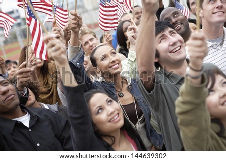 Group of multiethnic people holding up American flags