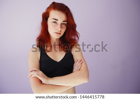 Stylish redhead gitl in a black top. Woman spend time in a dance studio