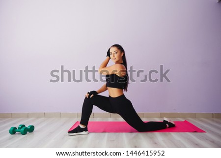 Stylish brunette in a black top. Woman spend time in a gym