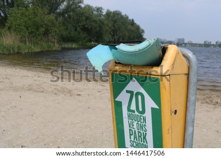 trash can next to water body Royalty-Free Stock Photo #1446417506