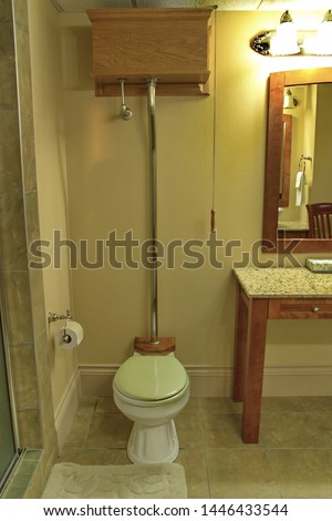 A modern, vintage style, High Tank pull chain toilet. Royalty-Free Stock Photo #1446433544