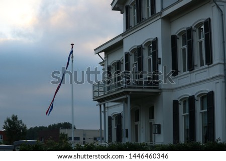 White building with flag hanging out Royalty-Free Stock Photo #1446460346