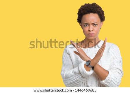 Beautiful young african american woman wearing sweater over isolated background Rejection expression crossing arms doing negative sign, angry face