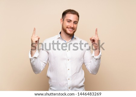 Blonde man over isolated background pointing up a great idea