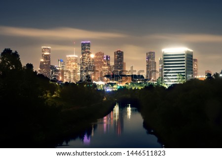 View of the lights of night Houston from the bridge over the Buffalo Bayou River. Reflections of buildings in the water.