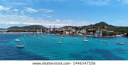 Waterside aerial photo coastline of Santa Ponsa town in the south-west of Majorca Island. Located in the municipality of Calvia, moored yachts on the turquoise tranquil bay of Mediterranean Sea, Spain
