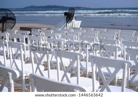 White chairs stand on the beach in rows. Outdoor conference. Religious meeting of the church for the wedding. Stock photo