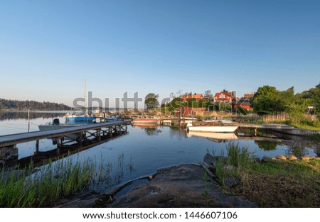 Summer in Swedish countryside - morning landscape with boats and traditional red houses. Vacation on Stockholm Archipelago in Baltic sea, cozy Scandinavian village