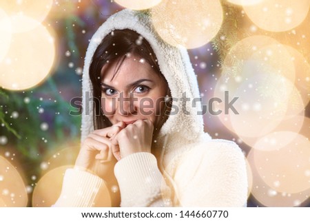 Beautiful young woman in winter forest surrounded by sparkling bokeh circles lights.