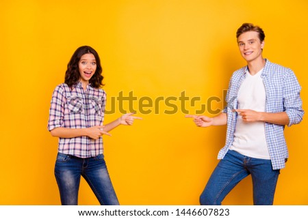 Close up photo of pair stand opposite he him his she her lady boy hands show to empty space on new prizes in store mall shop wear casual denim jeans plaid shirts outfit isolated on yellow background