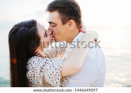 Close up photo of a happy kissing couple. Beautiful woman and handsome man cuddling.