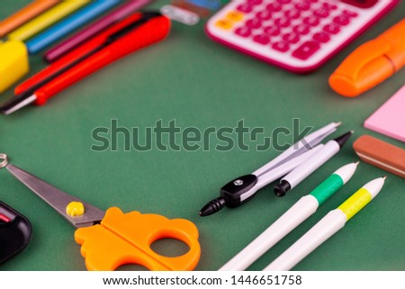 School office supplies stationery on a green background desk with copy space. Back to school concept