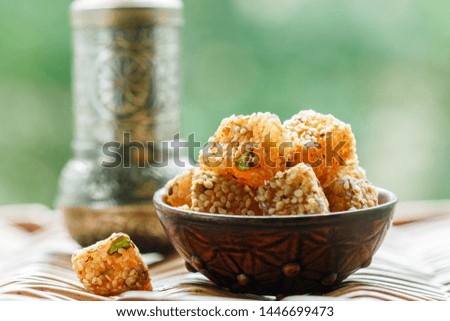 Traditional Turkish delight. lokum. Oriental sweets with sesame and pistachios in a ceramic bowl on the table. A treat for tea. Selective focus, copy space