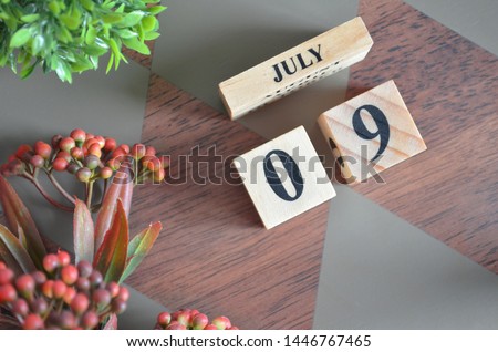 July 9. Date of July month. Diamond wood table for background.