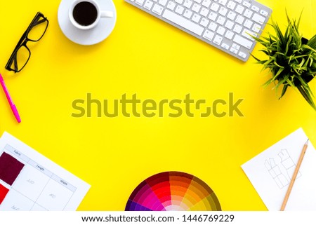 Designer office desk with tools, pallet, coffee, keyboard and glasses on yellow background top view mock up