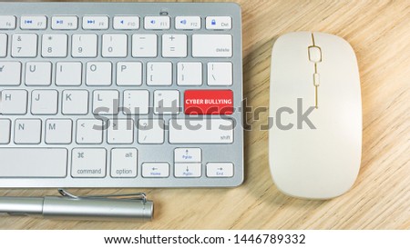 The cyber bullying red button on silver keyboard .
