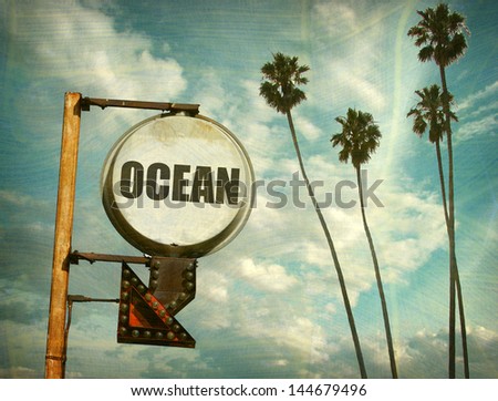 aged and worn vintage photo of ocean sign and palm trees