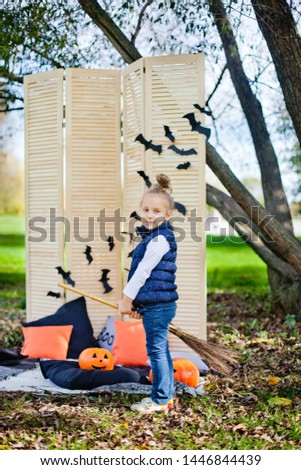girl on Halloween playing with a broom witch