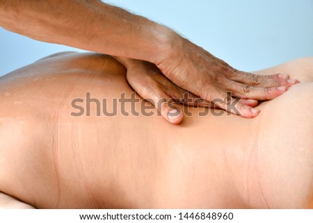 Сlose-up masseur hands doing back massage in spa center. low key photo