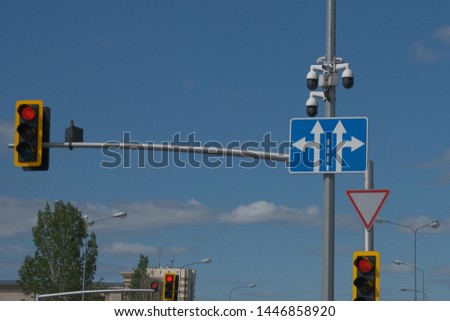 RED Traffic Light in the City, video surveillance cameras, traffic signs,against the blue sky.