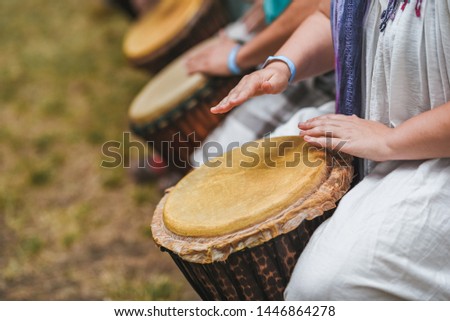People playing hand drums during an outdoor workshop