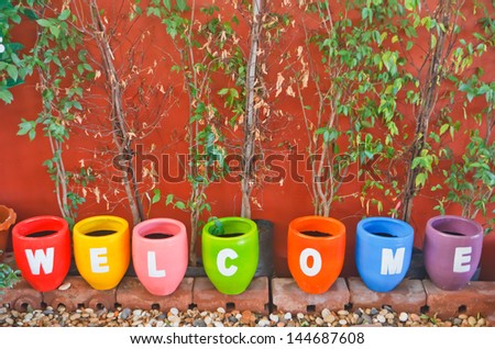 Welcome sign, at the flower pot.