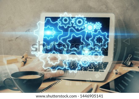 Double exposure of businessman working on laptop on background. International business hologram in front. Concept of success.