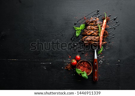 Pork steak on the fork. On a wooden background. Top view. Free space for your text. Royalty-Free Stock Photo #1446911339