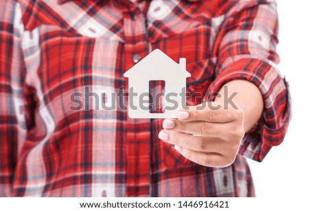 Woman with figure of house, closeup. Mortgage concept