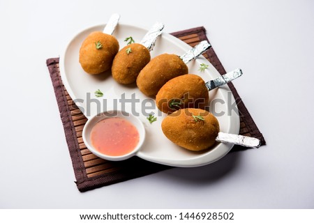 Crispy Veg lollipop recipe made using boiled potato with spices covered with corn flour and bread crumbs coating and then deep fried, served with toothpick or ice cream stock inserted in it with sauce