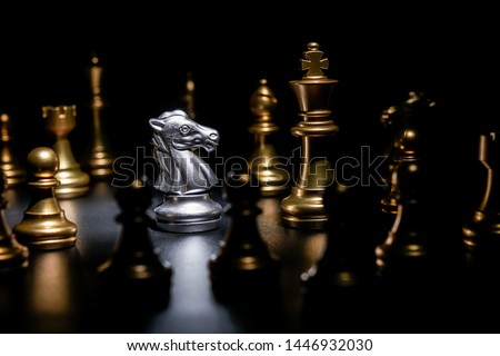 knight silver chess surrounded by gold chess on black background, business strategy concept