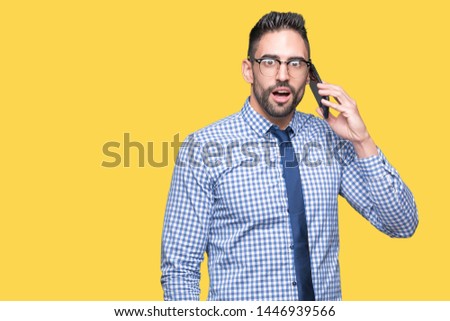 Young business man talking on the phone over isolated background scared in shock with a surprise face, afraid and excited with fear expression