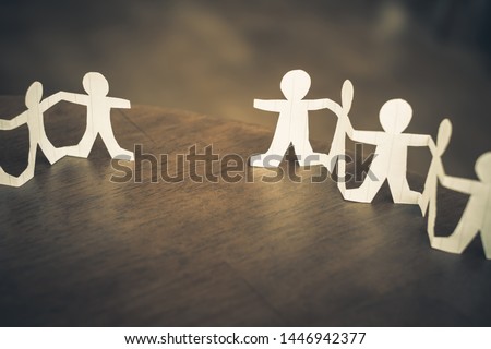 Two paper human chains disconnect or loosing doll in a role of team, teamwork or connection concept Royalty-Free Stock Photo #1446942377