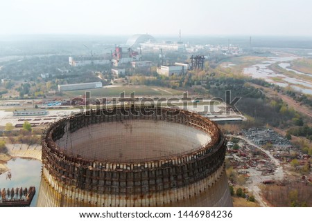 Flying over the cooling tower near the Chernobyl nuclear power plant. Territory near the Chernobyl NPP. Piles of metal and equipment contaminated by radiation are on special sites. Exclusion Zone. Royalty-Free Stock Photo #1446984236