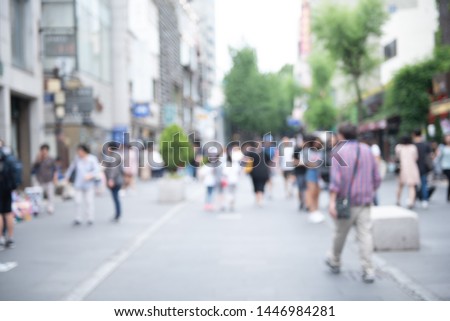 Blurred background, people walking at outdoor street market, business area in the city. Crowd street in Korea. Summer Holiday Shopping