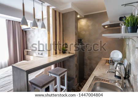 View of the kitchen and bar in a small hotel room - studio Royalty-Free Stock Photo #1447004804