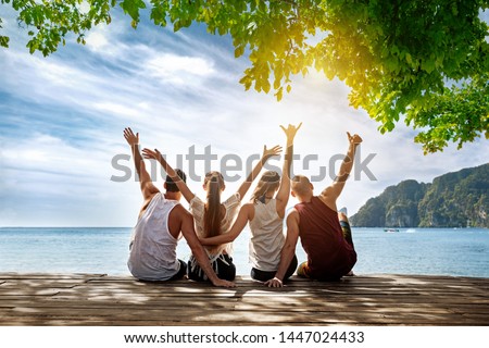 Group of happy friends is sitting and hugging at idyllic sea beach. Phi-phi island, Krabi, Thailand Royalty-Free Stock Photo #1447024433