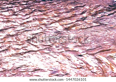 Abstract natural background with texture of flowing water surface in a river, purple pink liquid with waves with a copy space