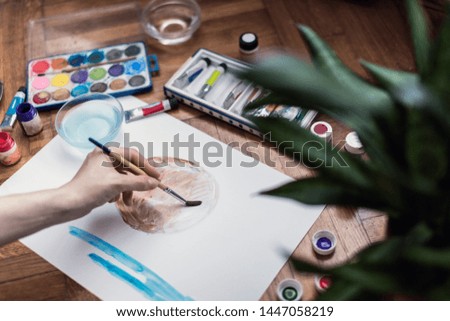 Woman painting with watercolors in her studio