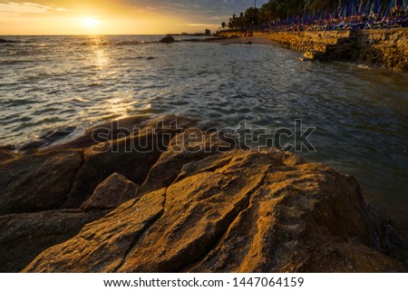 The rock on the sea with sunset sky 
