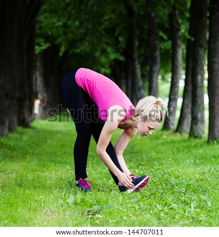 Young woman  stretching  in the park