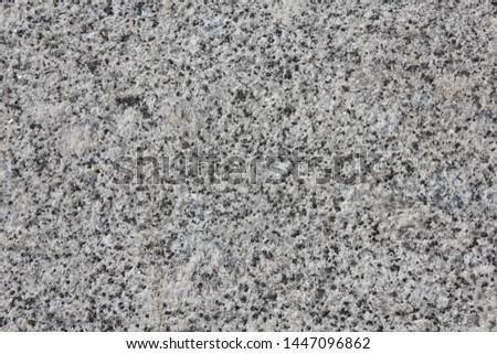 Texture of processed granite for designer background. Rough monochrome surface. Stone backdrop. Raster image.